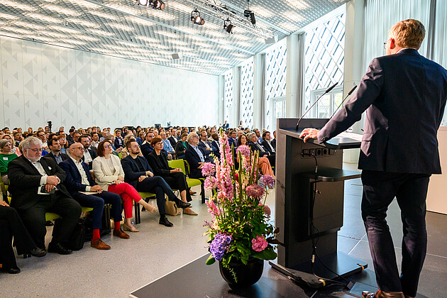 Professor Christopher Baum hält eine feierliche Ansprache am Rednerpult zur Übergabe der Nationalen Strategie für gen- und zellbasierte Therapien. Im Hintergrund sitzen die ZuhörerInnen.  